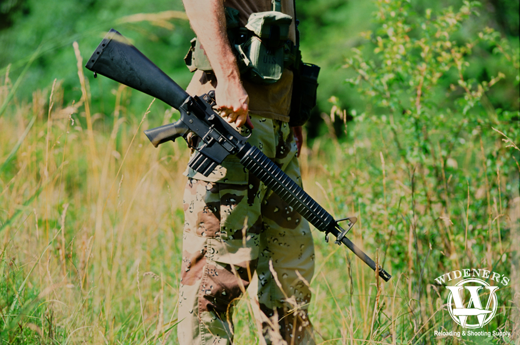 man holding a Colt M16A2 captured on a Nikon F3 camera a photo of a man holding a Colt M16A2 captured on a Nikon F3 camera