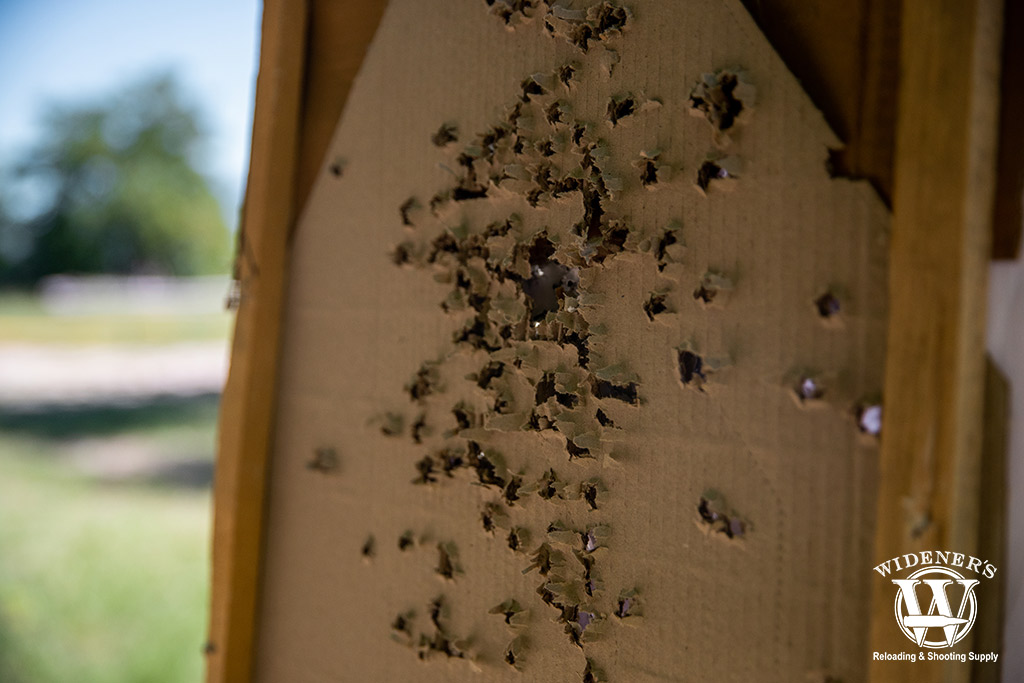 a carboard target outdoors at a gun range a photo of a carboard target outdoors at a gun range with holes from ball ammo