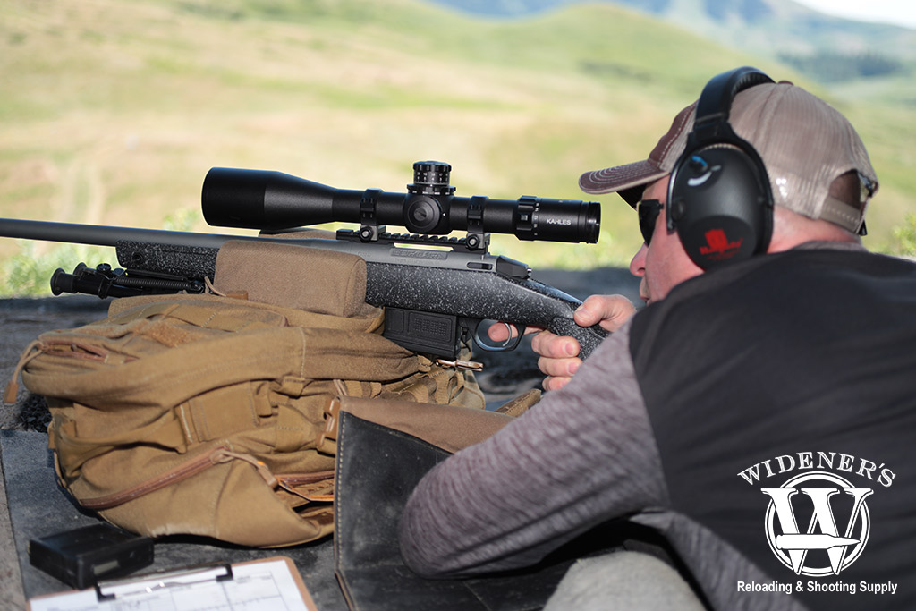 a photo of a man shooting a bolt action rifle