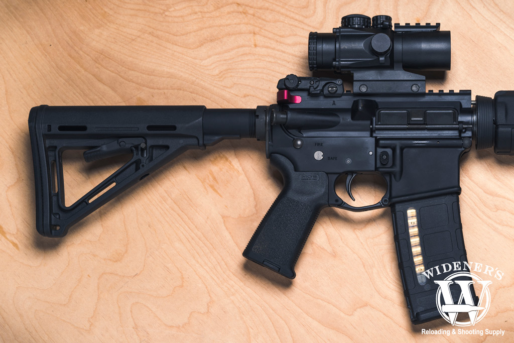 an ar15 rifle with magpul accessories and a 30 round pmag magazine photo of an ar15 rifle on plywood