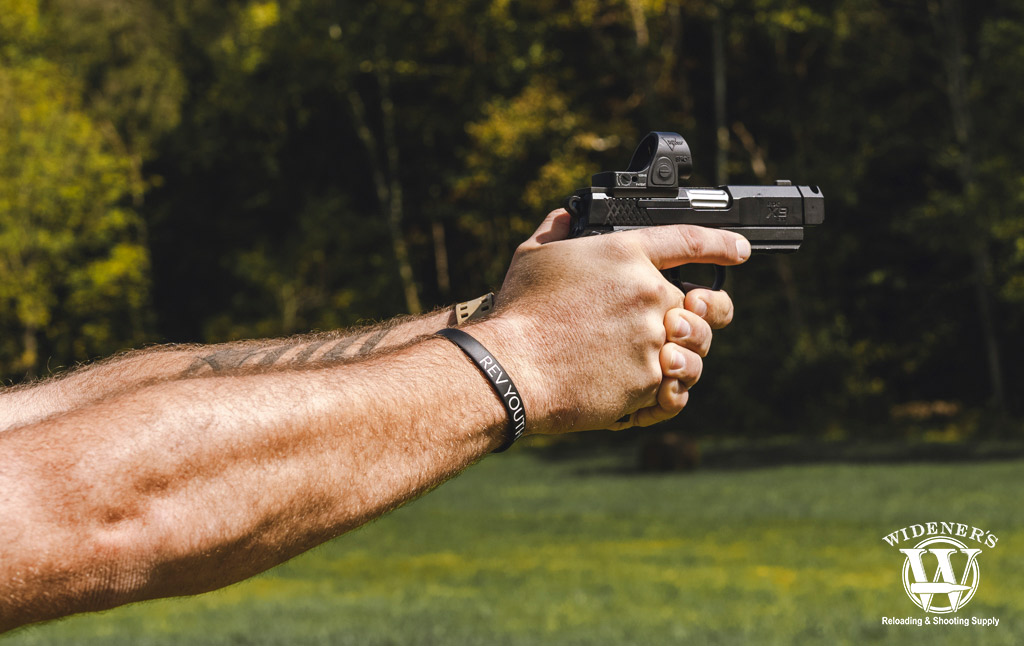a photo of a man shooting a handgun outdoors