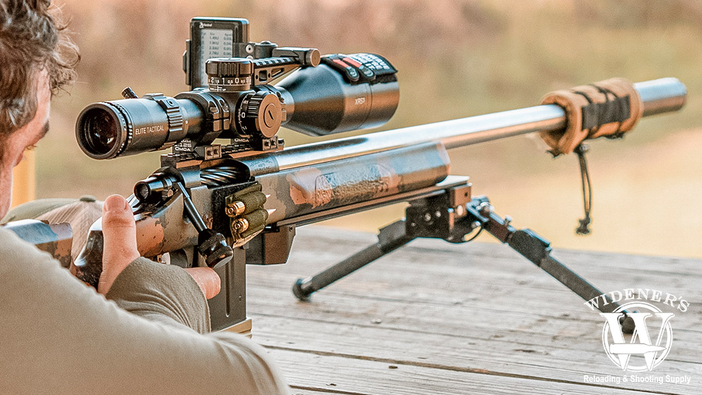 a photo of a man looking through the scope of a rifle