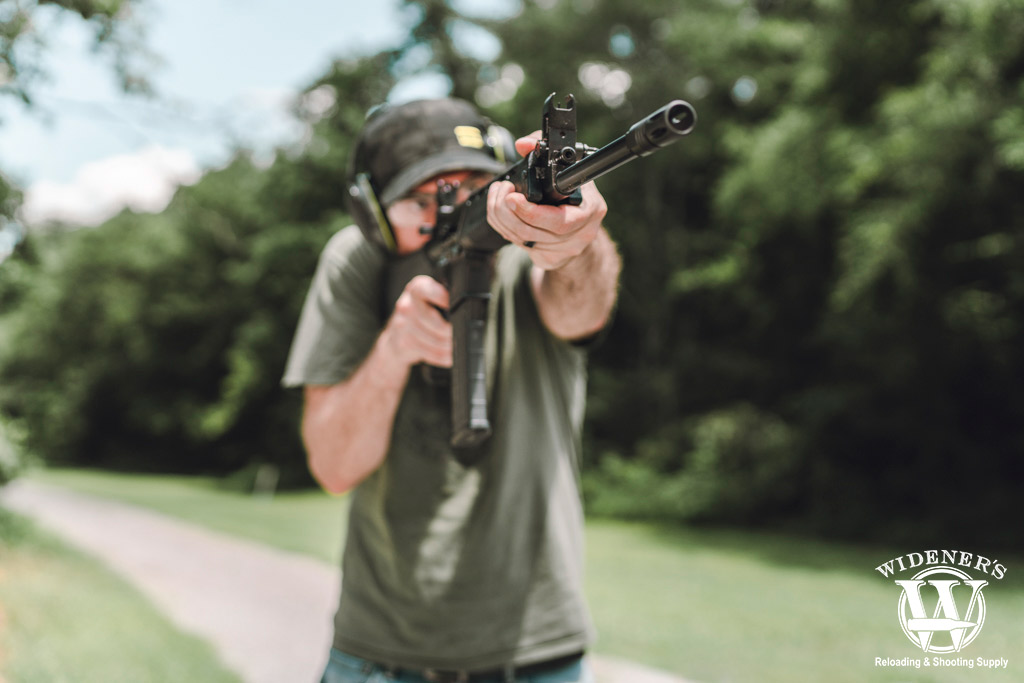 a photo of a man shooting a piston driven ar-15 outdoors