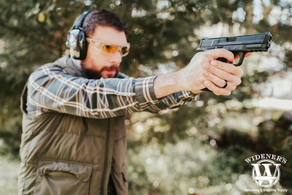 a man shooting a handgun outdoors a photo of a man shooting a handgun outdoors