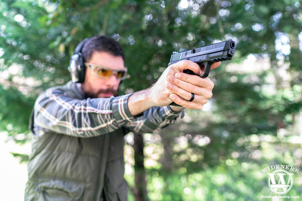 a photo of a man shooting an S&W handgun