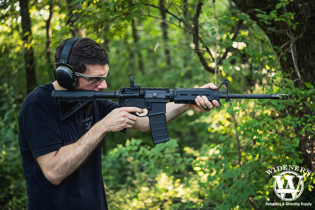 a man shooting an ar-15 rifle outdoors a photo of a man shooting an ar-15 rifle outdoors