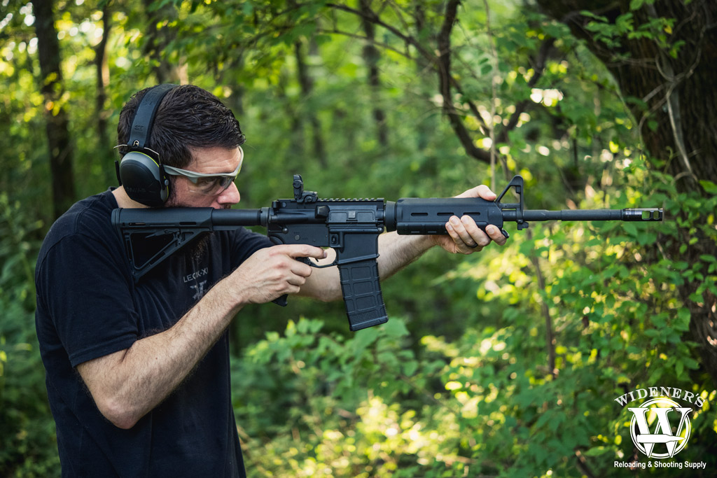 man shooting an ar-15 rifle in the woods a photo of a man shooting an ar-15 rifle in the woods