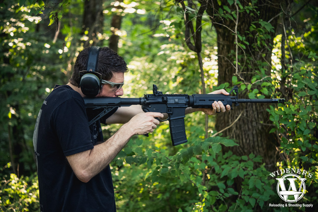 man shooting an ar-15 rifle outdoors a photo of a man shooting an ar-15 rifle outdoors