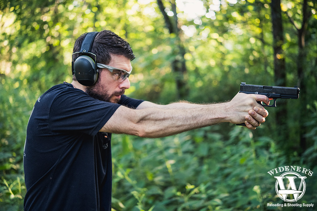 a man shooting a glock 17 pistol outdoors a photo of a man shooting a glock 17 pistol outdoors