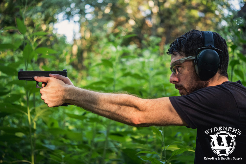 a man shooting a glock semi auto pistol outdoors a photo of a man shooting a glock semi auto pistol outdoors