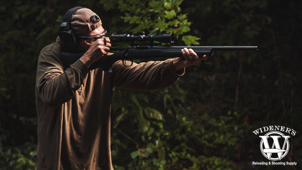 a photo of a man shooting a bolt action rifle