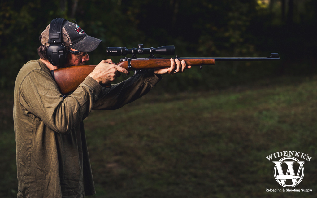 man shooting a rifle outdoors a photo of a man shooting a rifle outdoors