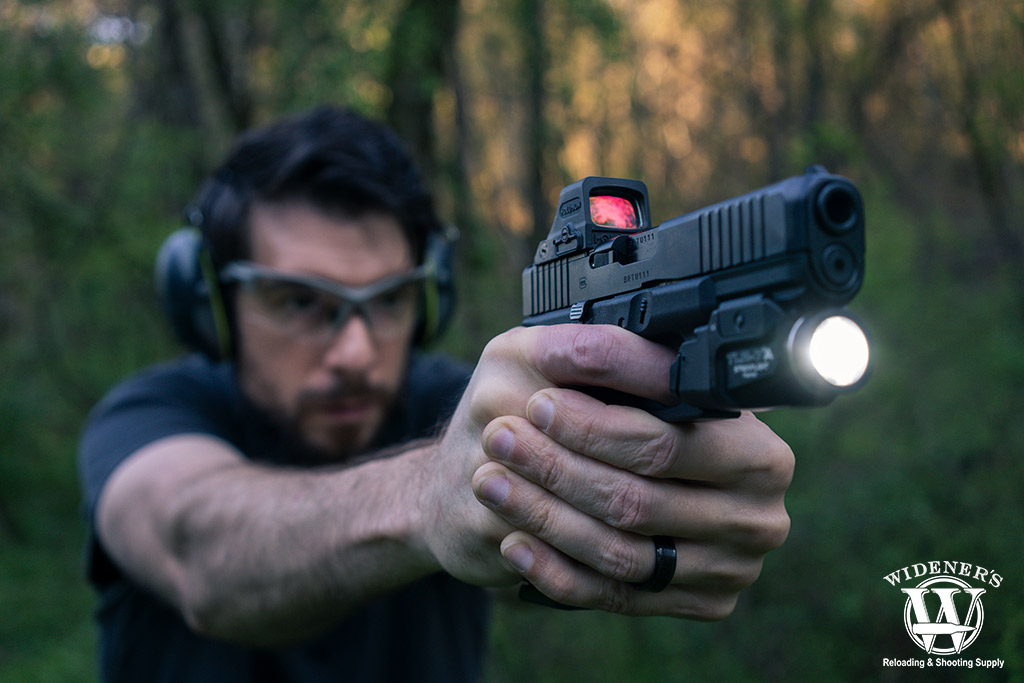 man shooting a pistol outdoors A photo of a man shooting a pistol outdoors red dot vs holographic