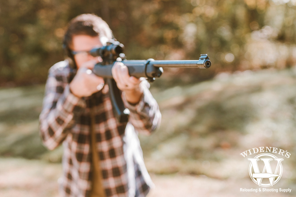 man shooting a rimfire rifle outdoors a photo of a man shooting a rimfire rifle outdoors