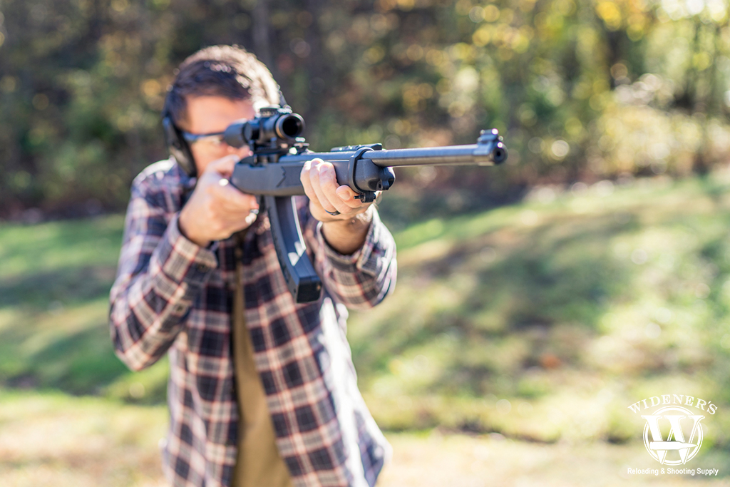 a photo of a man shooting a rimfire rifle
