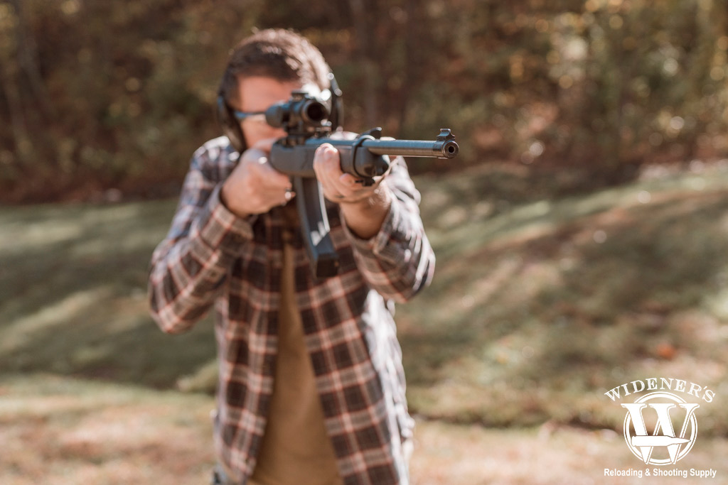 man shooting a rimfire rifle outdoors a photo of a man shooting a rimfire rifle outdoors