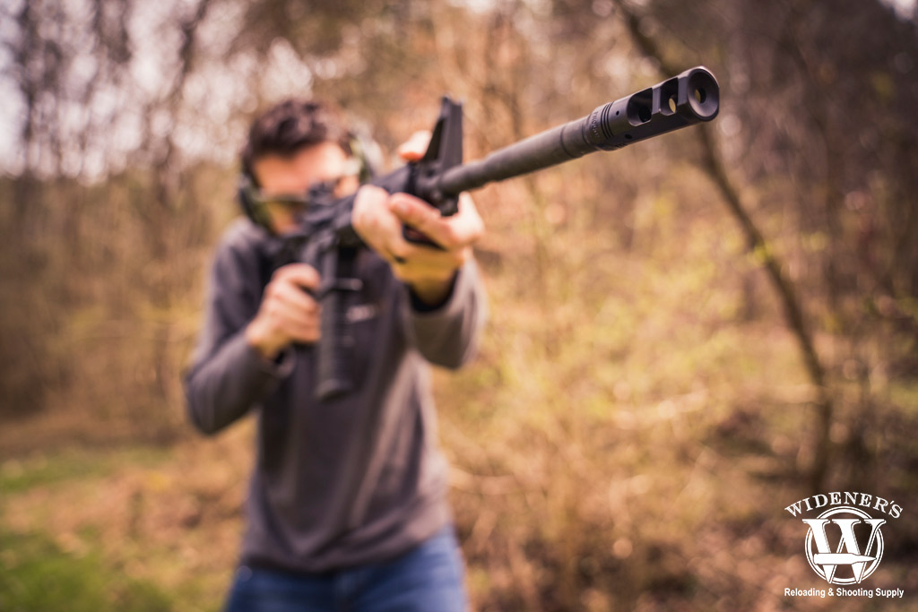 man shooting a rifle in the woods a man shooting a rifle in the woods