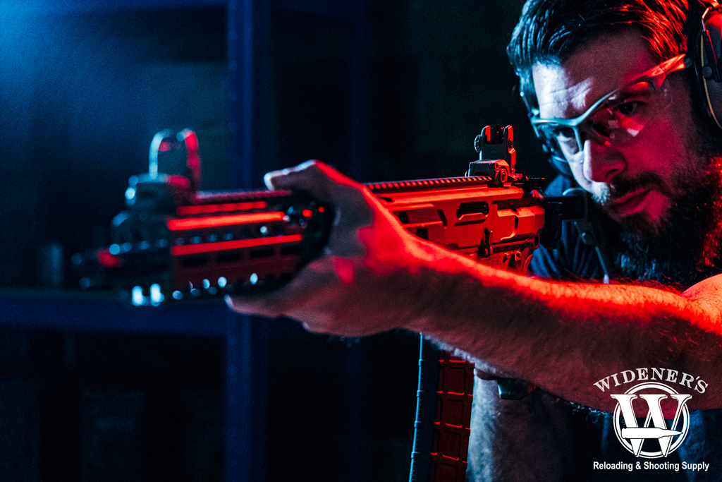 a photo of a man shooting a semi auto rifle with iron sights