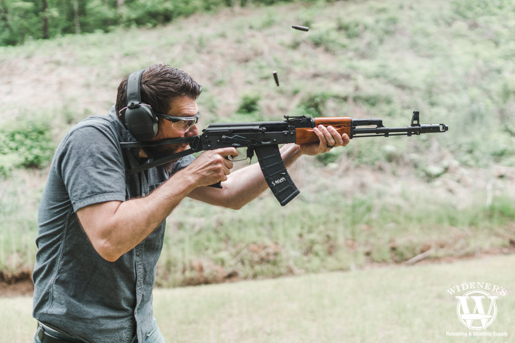 man shooting an ak74 rifle outdoors a photo of a man shooting an ak74 rifle outdoors