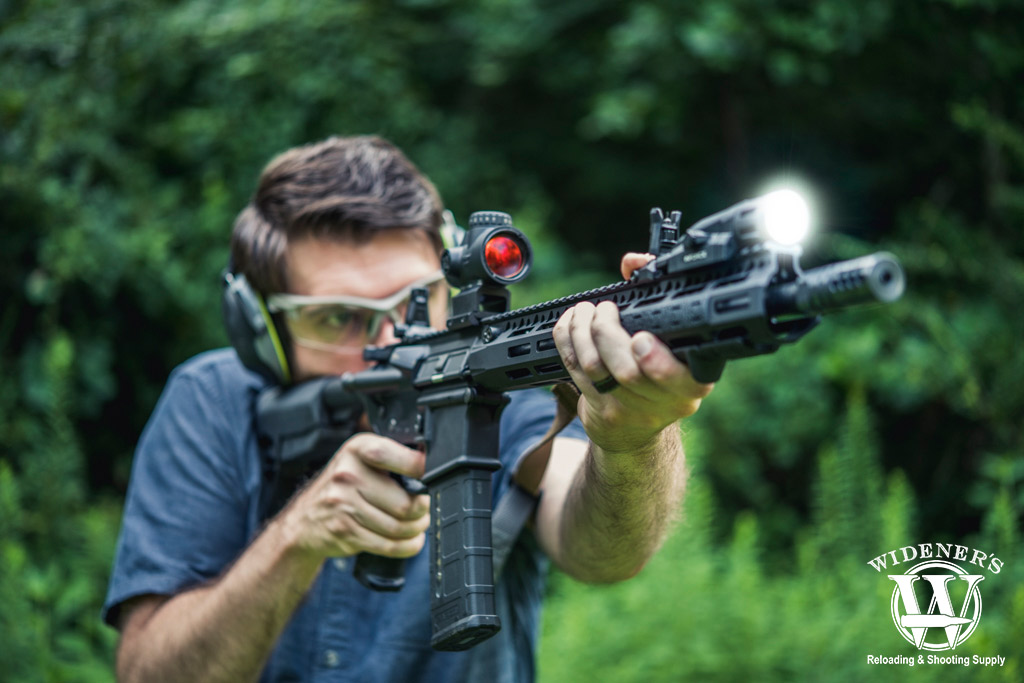 a photo of a man shooting an ar-15 rifle with lower 1/3 co-witness sights