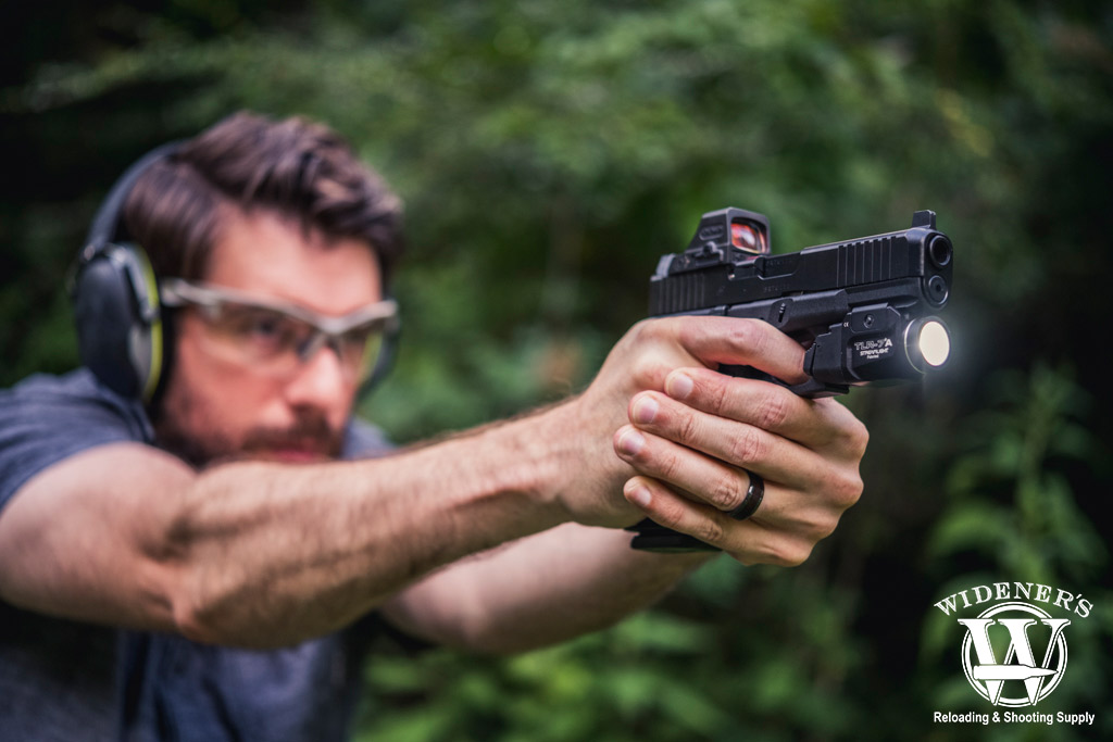 a man shooting a glock pistol at a gun range