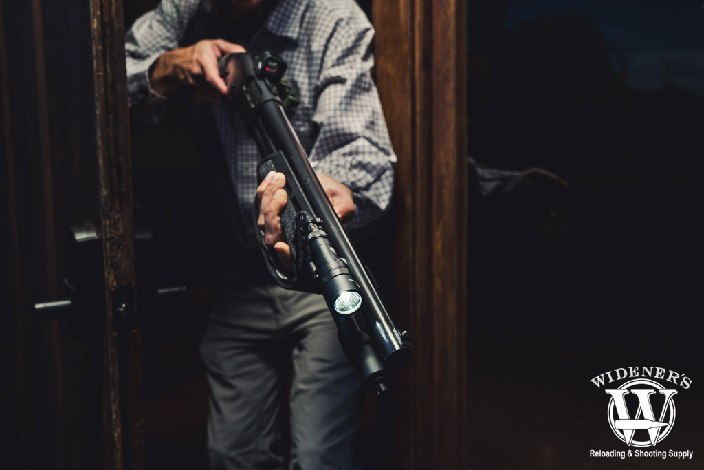 a man holding home defense shotguns at night a photo of a man holding home defense shotguns at night