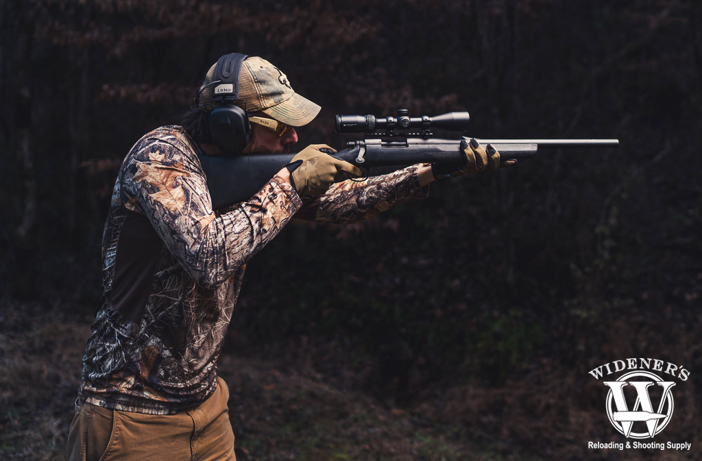 a photo of a man shooting a Remington 700 short-action rifle