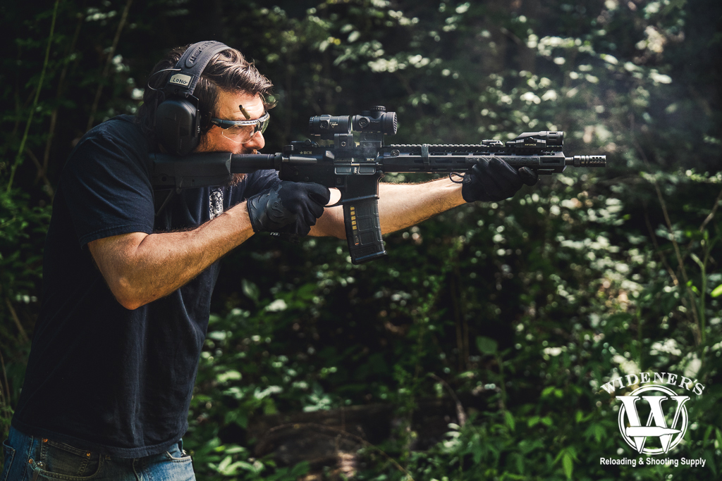 comparing AK-47 vs AR-15 rifles a photo of a man comparing AK-47 vs AR-15 rifles