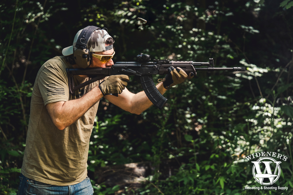 comparing AK-47 vs AR-15 rifles a photo of a man comparing AK-47 vs AR-15 rifles