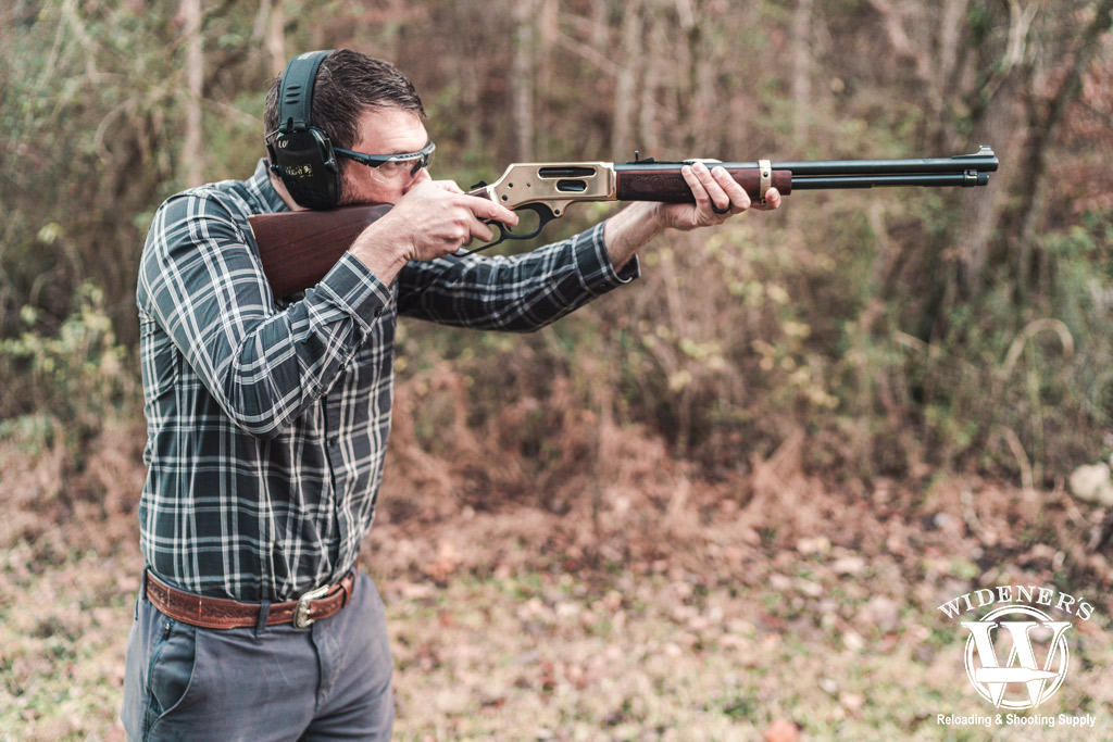 a photo of a man shooting a lever action rifle