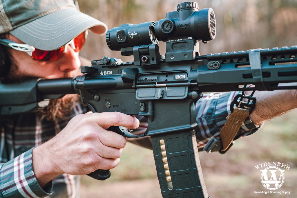 man using a red dot magnifier on an ar-15 rifle a photo of a man using a red dot magnifier on an ar-15 rifle