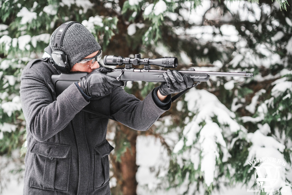 man shooting a bolt action rifle in the snow a photo of a man shooting a bolt action rifle in the snow
