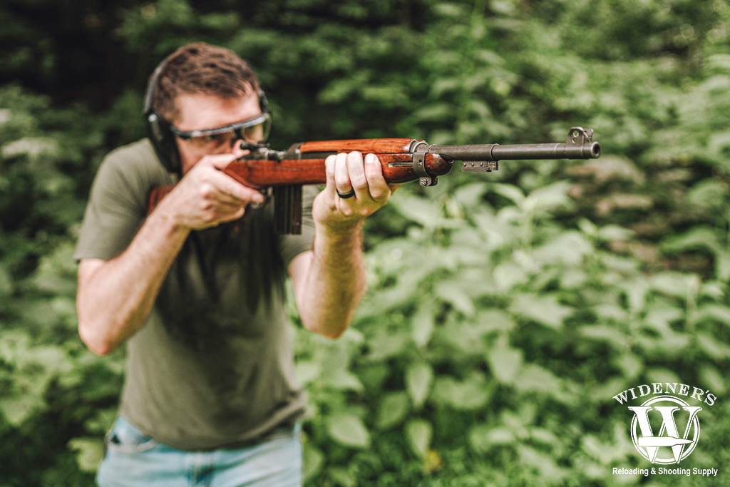 a photo of a man shooting a carbine rifle