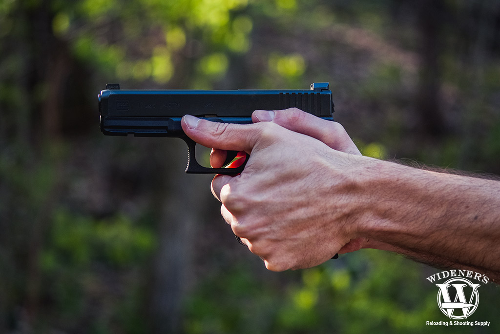 a photo of a man shooting a glock handgun outdoors
