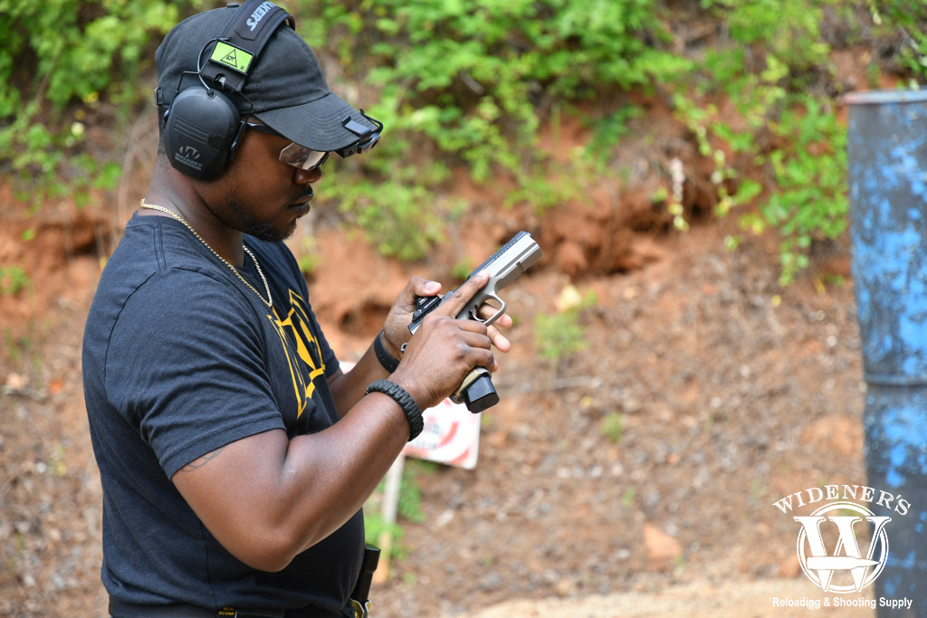 safely handing a gun at the range a photo of a man safely handing a gun at the range