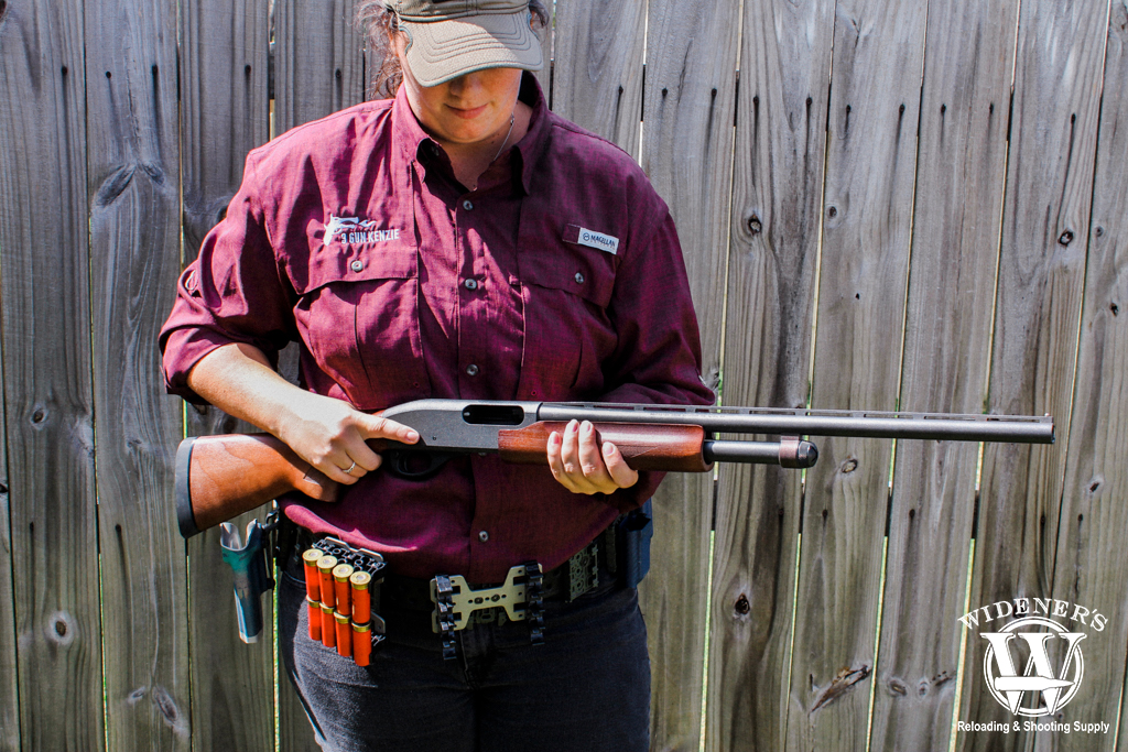 a female holding a pump-action shotgun a photo of a female holding a pump-action shotgun