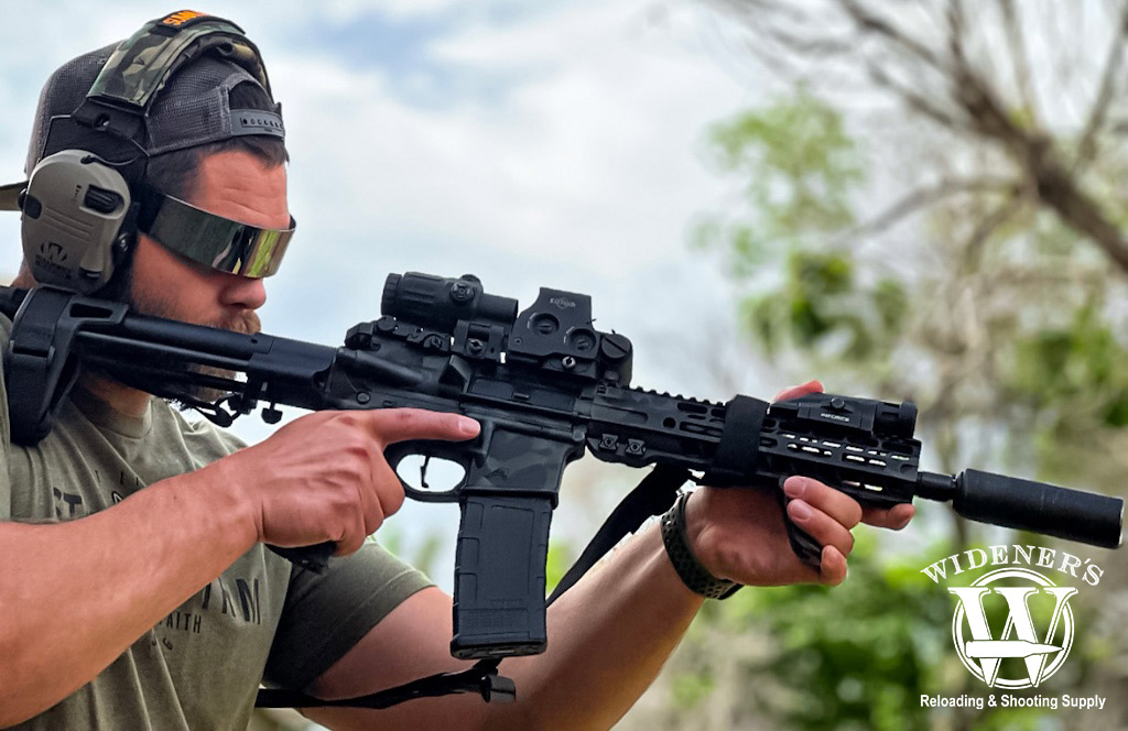 shooting a suppressed rifle chambered in 300 BLK a photo of a man shooting a suppressed rifle chambered in 300 BLK