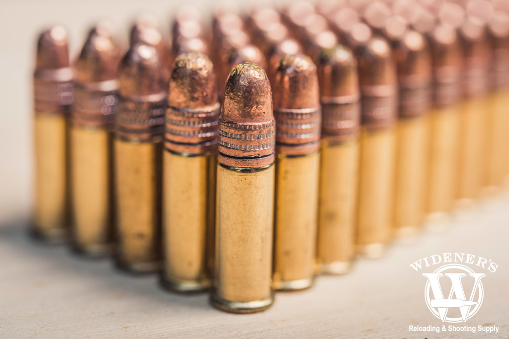 the popular .22 FMJ bullet uses its copper plating as a lubricant photo of copper plated .22 FMJ bullets stacked side by side on a sheet of plywood