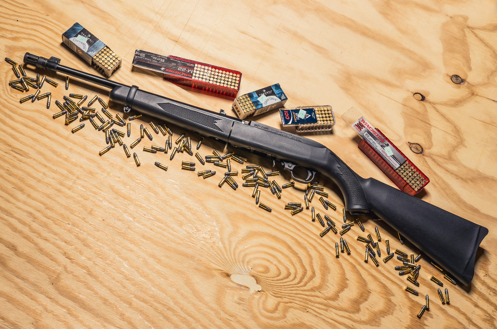 photo of a ruger 10 22 rifle with 22 LR ammo on a sheet of plywood