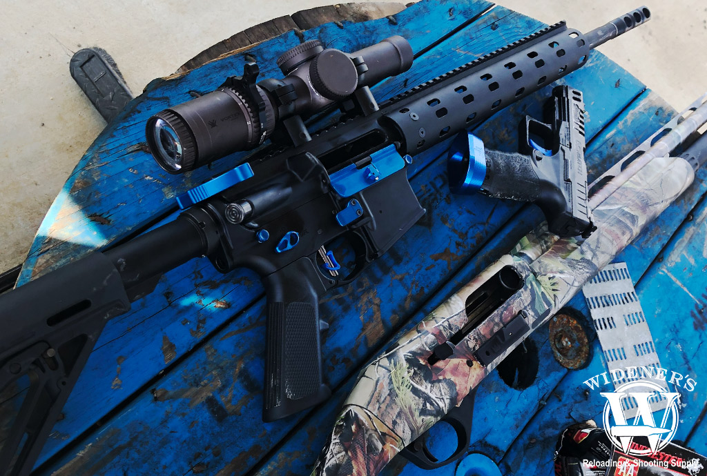 ar15 rifle 9mm pistol and 12 gauge shotgun a photo of a ar15 rifle 9mm pistol and 12 gauge shotgun on a table outdoors