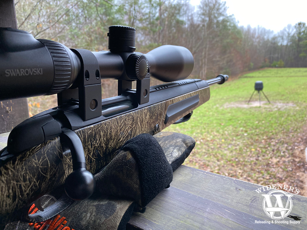 a photo of bolt action vs semi auto hunting rifle in a blind