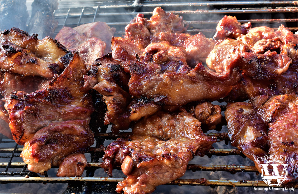 a photo of pork cooking on a grill