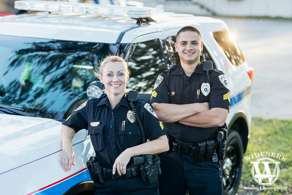 a photo of two police officers by their squad vehicle