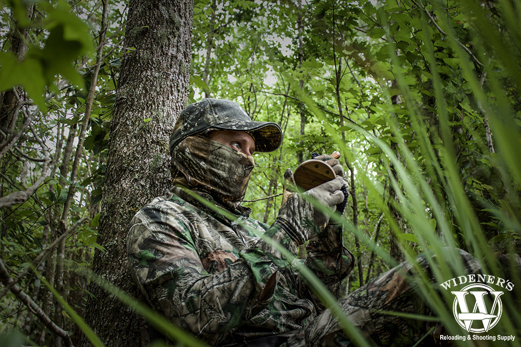 a photo of a man using a friction turkey call